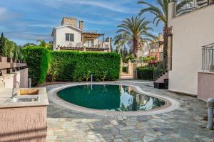 a swimming pool in a yard next to a house at Leda Beach Villa in Polis Chrysochous