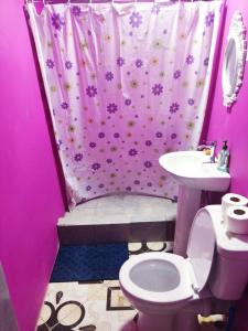 a pink bathroom with a toilet and a sink at Preferred Place in Trincity  +21 photos