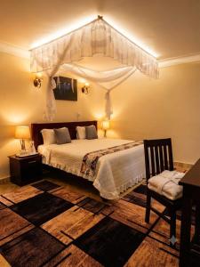 a bedroom with a large bed with a canopy at Coco Hotel Busia in Busia