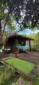 a house with a hammock on a wooden deck at Chalés Giramundo in Visconde De Maua