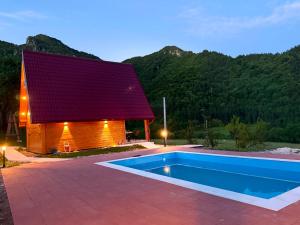 ein Haus mit Swimmingpool neben einem Gebäude in der Unterkunft Villa Viktor Šipovo in Šipovo