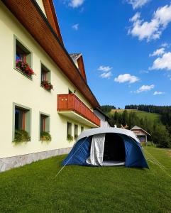 a tent in the grass next to a building at Camping & Glamping Čenda in Železniki +26 photos