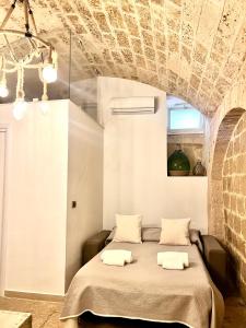 a bed in a room with a brick wall at L’Antica Dimora in Bari