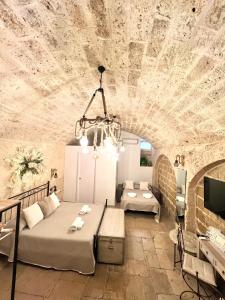 a room with two beds and a couch and a tv at L’Antica Dimora in Bari