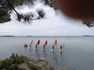 a group of people on a lake with sailboats at Sterne pierregarin 2kms de la plage in Séné +4 photos