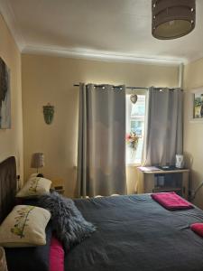 a bedroom with a bed and a window with curtains at Shalom, in Saundersfoot, near the sea in Saundersfoot