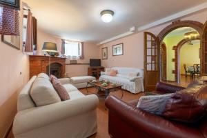 a living room with two couches and a fireplace at CASALE LE CONCE 6, Emma Villas in Castel del Piano