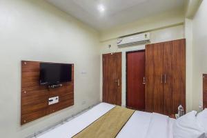 a bedroom with a bed and a flat screen tv at Hotel Sky in Dwarka