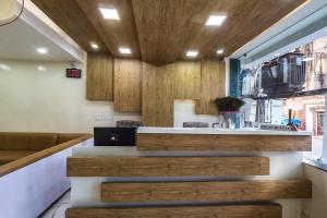 a bar in a restaurant with wooden walls and stairs at Hotel Sky in Dwarka