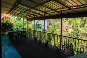 eine Terrasse mit Tisch und Stühlen auf einem Balkon in der Unterkunft Trailside Ella-Your Gateway to Ella Rock in Ella