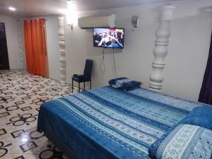 a bedroom with a bed with a tv on the wall at Preferred Place in Trincity 