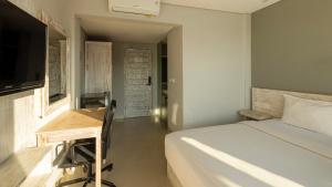 a bedroom with a bed and a desk and a television at Shashvata Berawa in Badung +7 photos