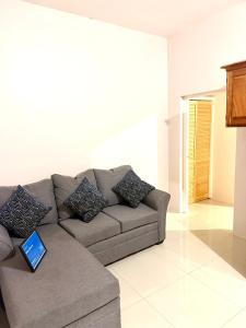 a living room with a couch with a laptop on it at Olive Breeze III in Runaway Bay