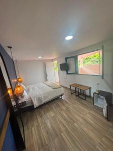 a bedroom with a bed and a table and a window at Hotel Tumbaga 88 in Salento