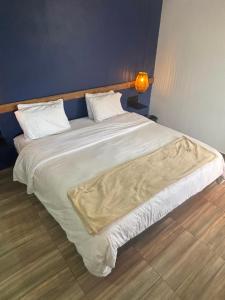 a large bed with white sheets and pillows at Hotel Tumbaga 88 in Salento
