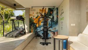 a room with a gym with a treadmill at Shashvata Berawa in Badung