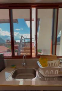 a kitchen counter with a sink and a window at La Casita de Merme in Oxapampa