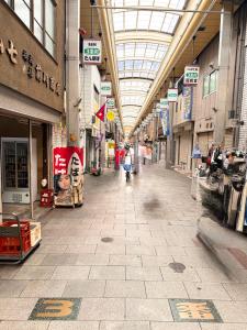an empty shopping mall with a person holding an umbrella at Lee house 佳 別荘 一戸建て貸切の宿 in Osaka