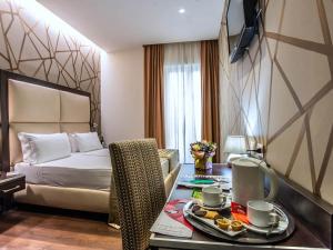 a hotel room with a bed and a table with a tray of food at Hotel Infinity San Pietro in Rome