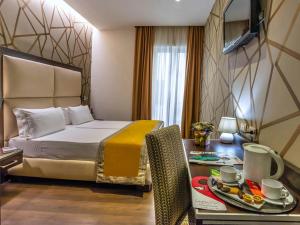 a hotel room with a bed and a table with a tray at Hotel Infinity San Pietro in Rome