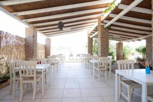a row of tables and white chairs on a patio at Masseria SoleMare Gallipoli in Pizzo +13 photos