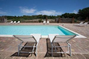 a pool with two chairs and a table next to it at Masseria SoleMare Gallipoli in Pizzo