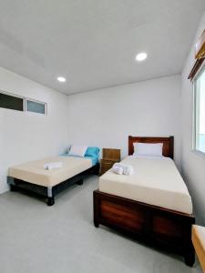 a bedroom with two beds and a window at Suite Meridiano Direct Beach Access y AC in Ballenita