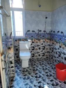 a bathroom with a toilet and a rock wall at Vatiguesthouse in Shillong