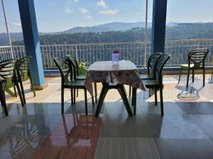 a table and chairs on a balcony with a view at Vatiguesthouse in Shillong
