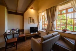 a living room with a couch and a tv and windows at San Agustin Monasterio de la Recoleta in Urubamba