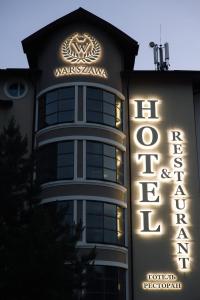 a building with a sign on the side of it at Warszawa Hotel in Lviv