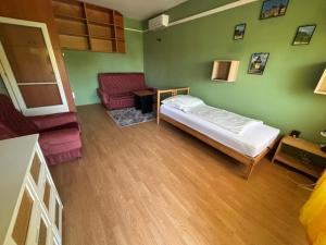 a room with a bed and a living room with a couch at Piszkei Apartman in Lábatlan