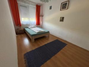 a small room with a bed and a window at Piszkei Apartman in Lábatlan
