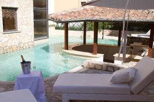 ein Pool mit einer weißen Couch und einem Sonnenschirm in der Unterkunft The Strand Hotel in Rom