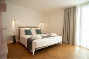 a bedroom with a large bed with white and blue pillows at Appartamento Costanza in Letojanni