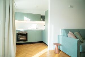 a living room with a blue couch and a kitchen at Appartamento Costanza in Letojanni