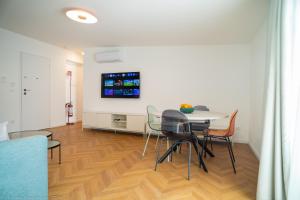 a dining room with a table and chairs and a tv at Appartamento Costanza in Letojanni