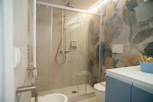 a bathroom with a glass shower with a toilet at Appartamento Costanza in Letojanni