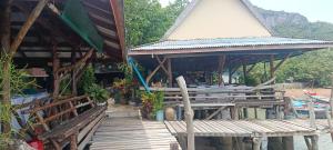 a building with a wooden deck with a table at Phaluay seefood Motel in Koh Phaluai