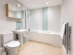 a bathroom with a toilet and a sink and a shower at Roomspace Serviced Apartments - Capitol Square in Epsom +13 photos