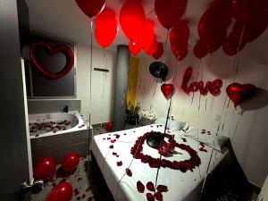 a room with red hearts on the wall and a bed with balloons at Hotel sahara in Medellín