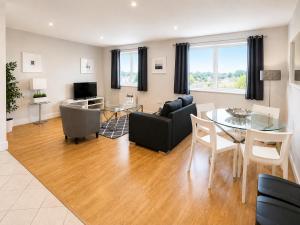 a living room with a table and a dining room at Roomspace Serviced Apartments - Capitol Square in Epsom