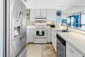 a white kitchen with a refrigerator and a sink at Sea Watch 1910 in Ocean City +52 photos
