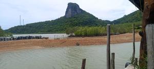 a body of water with a mountain in the background at Phaluay seefood Motel in Koh Phaluai