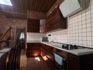 a kitchen with wooden cabinets and a counter top at Villa ZRUB in Palyanytsya