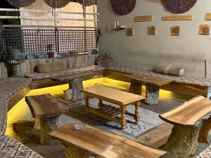 a room with wooden tables and benches in a room at MANOKUR - E- BASA HOTEl in Minapin