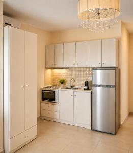 a kitchen with white cabinets and a stainless steel refrigerator at Angela Studios in Syvota +56 photos