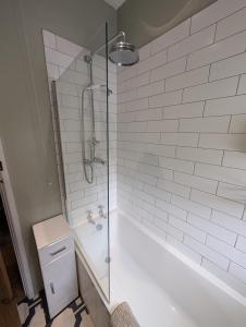 a bathroom with a shower and a tub and a toilet at Quaint Cottage in Charming Evesham in Evesham +6 photos