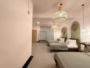 a hotel room with three beds and a chandelier at Crown Valley Boutique Lifestyle Hotel, Ella in Ella