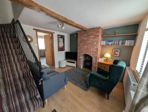 a living room with a staircase and a fireplace at Quaint Cottage in Charming Evesham in Evesham